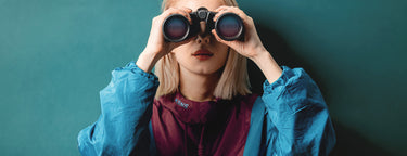 A woman clad in a KSNS jumper uses a telescope to glimpse future fashion trends.